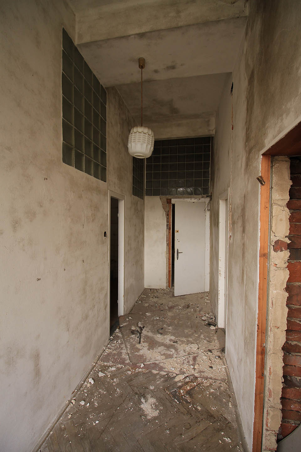 Úpravy z období socializmu vnesly do interiéru nové prvky. Chatrné příčky, luxfery a řasená stínidla lustrů. Po převratu přibyly ještě líbivé štítky klik a levné dveře.