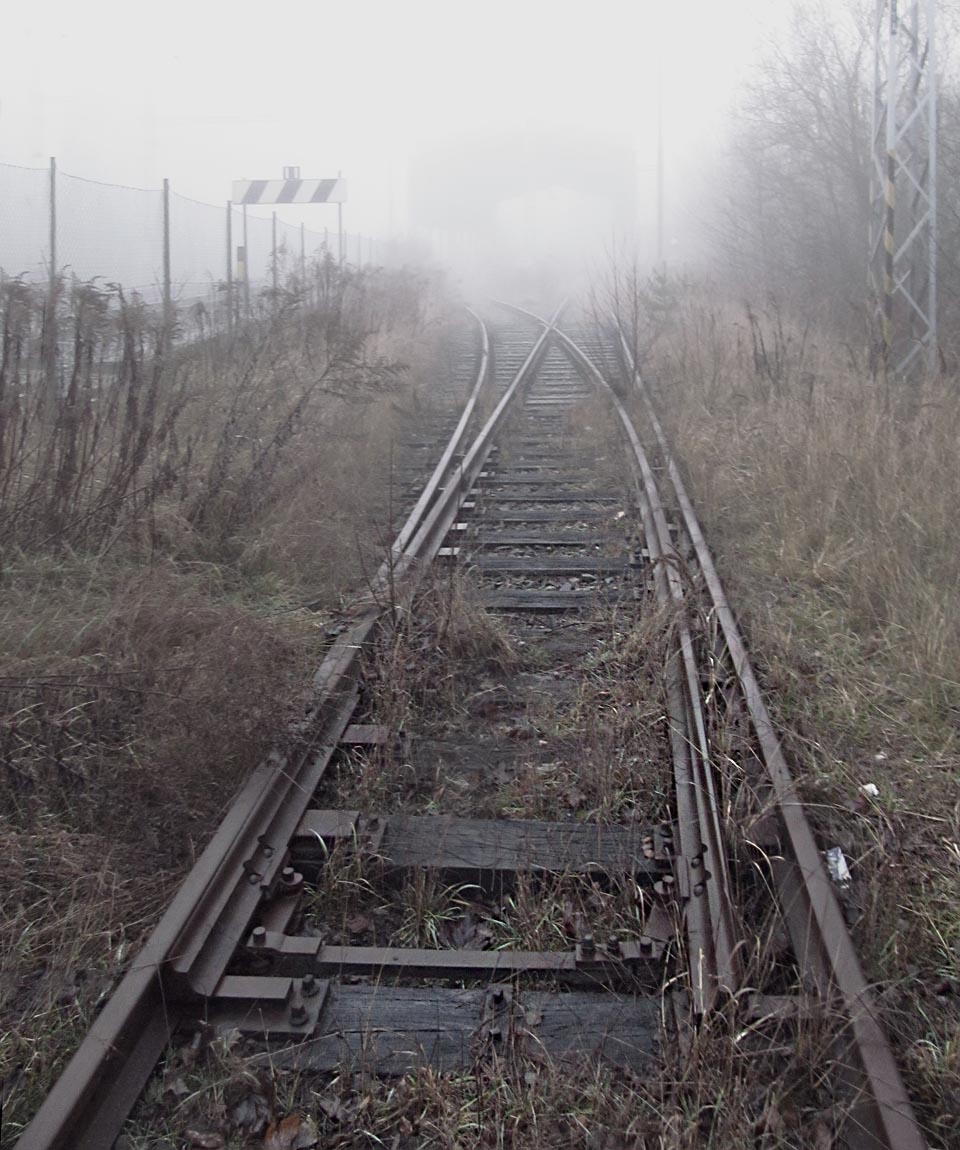 Je cosi mrazivého v tom kousku kolejí mezi železnicí spojující svět a bývalým koncentrákem od světa izolovaným ostnatým drátem a kulometnými věžemi.