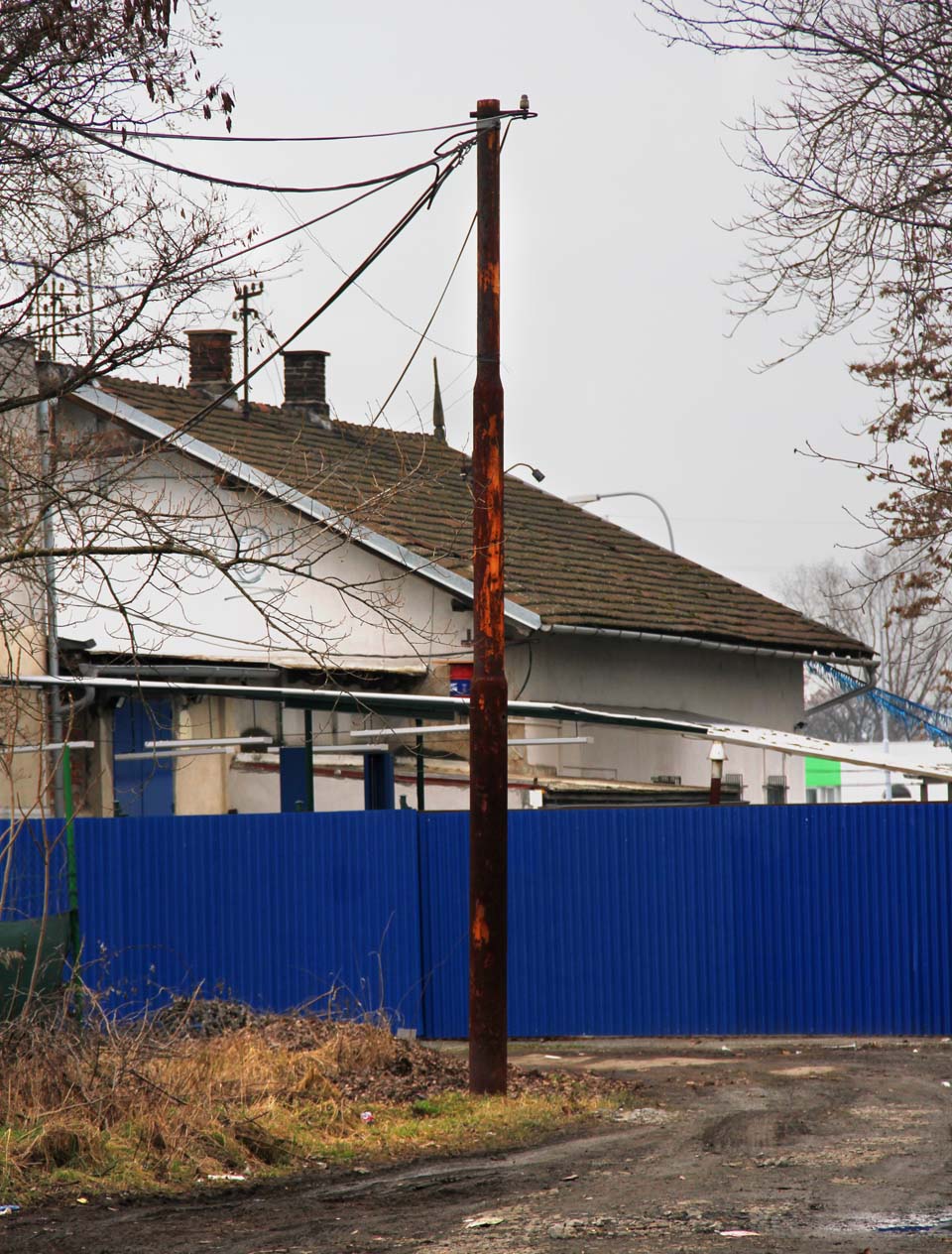 Rezivějící sloup trakčního vedení je poslední připomínkou elektrifikace - patrně již ale jen trolejbusové vozovny, která v areálu stanice dočasně působila.