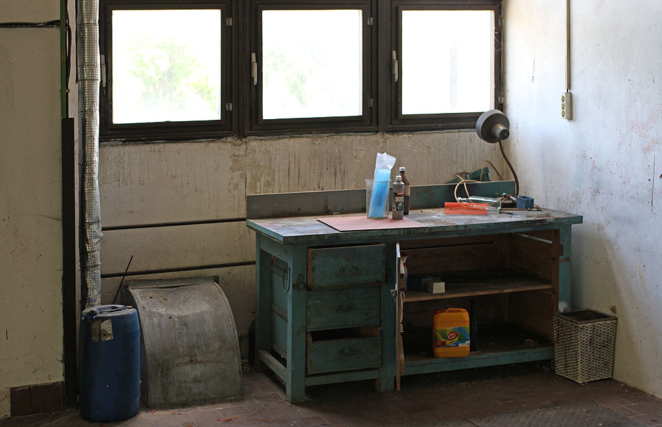 Dílenský, či snad laboratorní stůl se zbytky chemikálií - ať už s etiketami nebo bez nich.