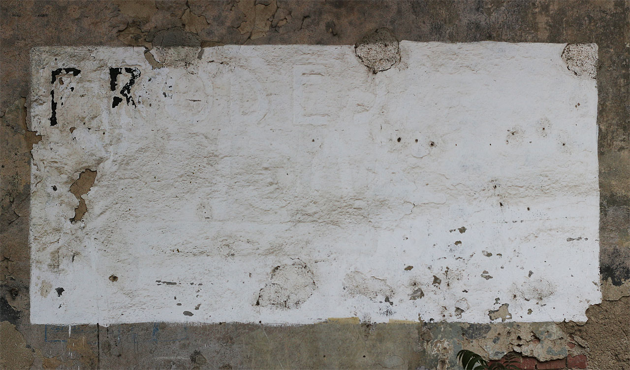 Nápis na omítce se nám nikdy nepodařilo rozlousknout. Secesní písmena sice oznamují prodej něčeho, ale čeho vlastně a v jaké době, zůstává (zatím) záhadou.