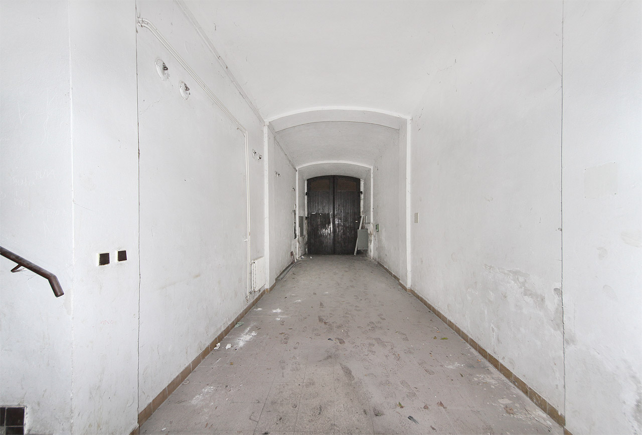 Sterilizovaný průjezd domu pozbyl veškerou svoji romantičnost již dávno. Do domu z něj vede jediný vchod.