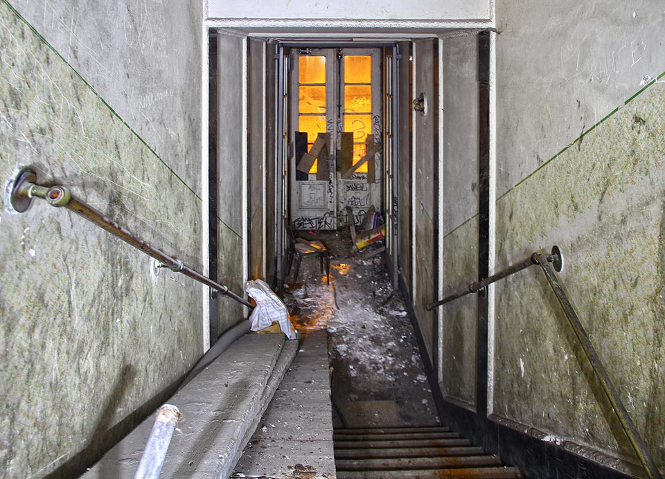 Pohled na schodiště za vstupními dveřmi naznačuje, že se tu někdo pokoušel neúspěšně o rekonstrukci.