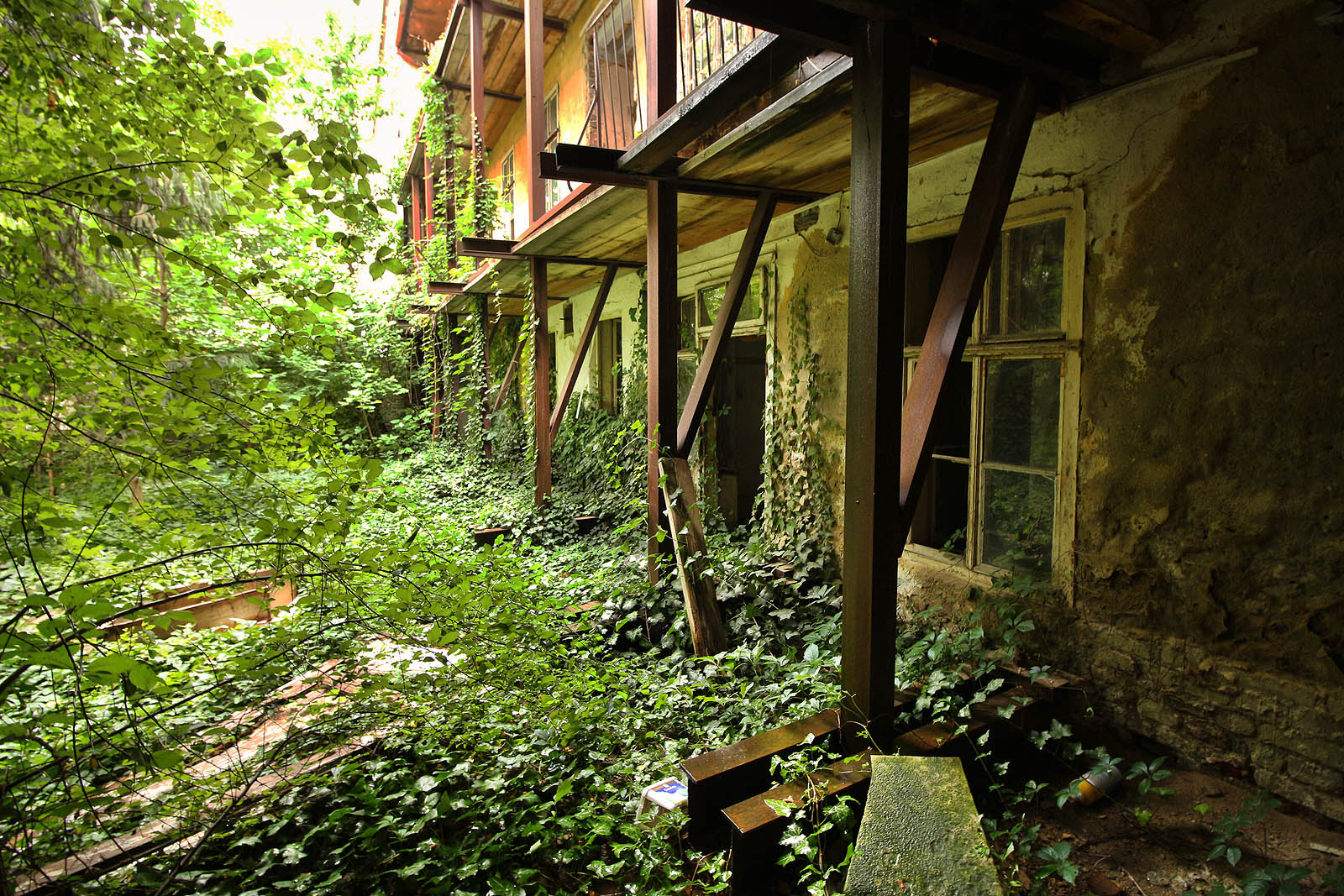 Ocelová konstrukce, která drží rozpraskaný dům pohromadě je dobře patrná také tady. Snad až příliš masivní nosníky drží pavlače a prochází skrze stěny domu do sklepení, kde na nich stojí celé zdi.