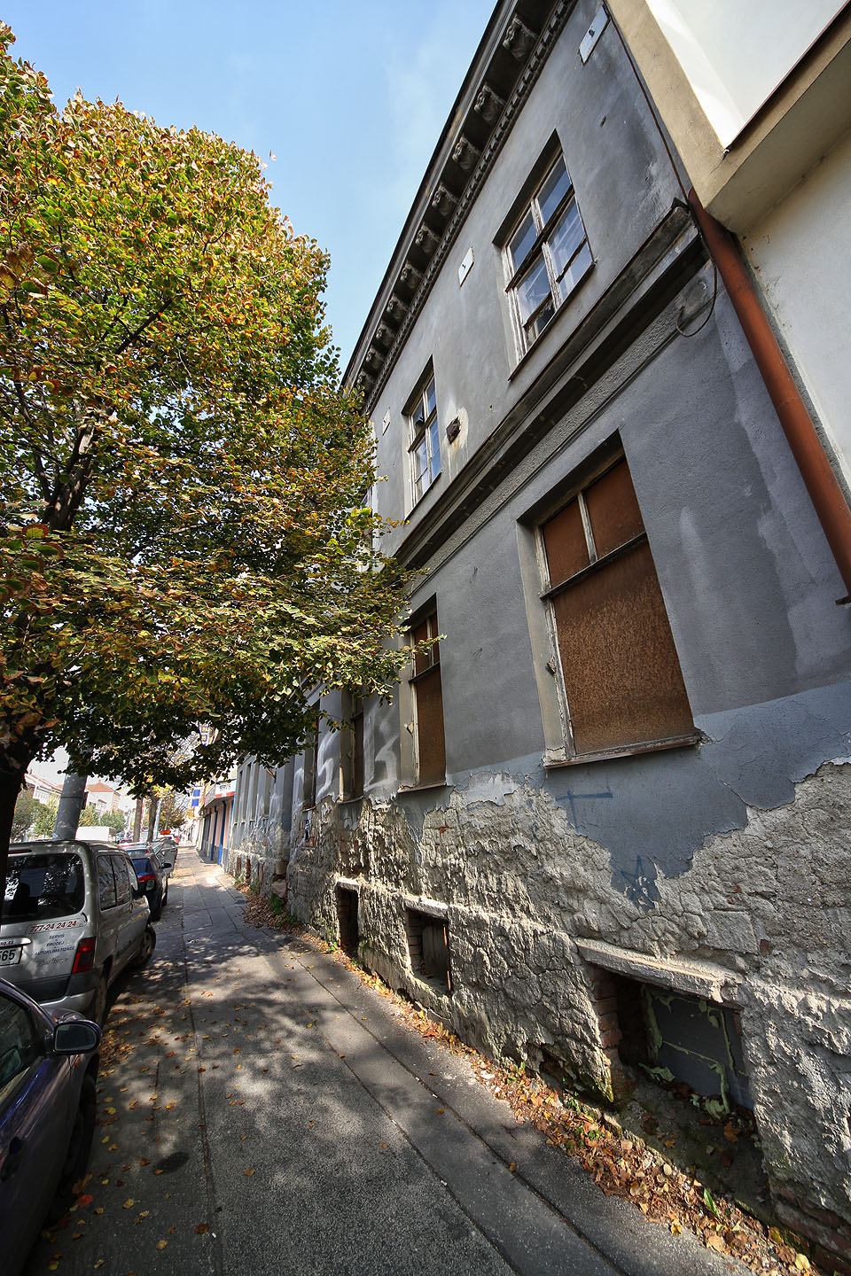 Dům je ze strany do ulice dobře zabezpečen proti vniknutí, okna i okénka jsou zazděna nebo bytelně zatlučena prkny…