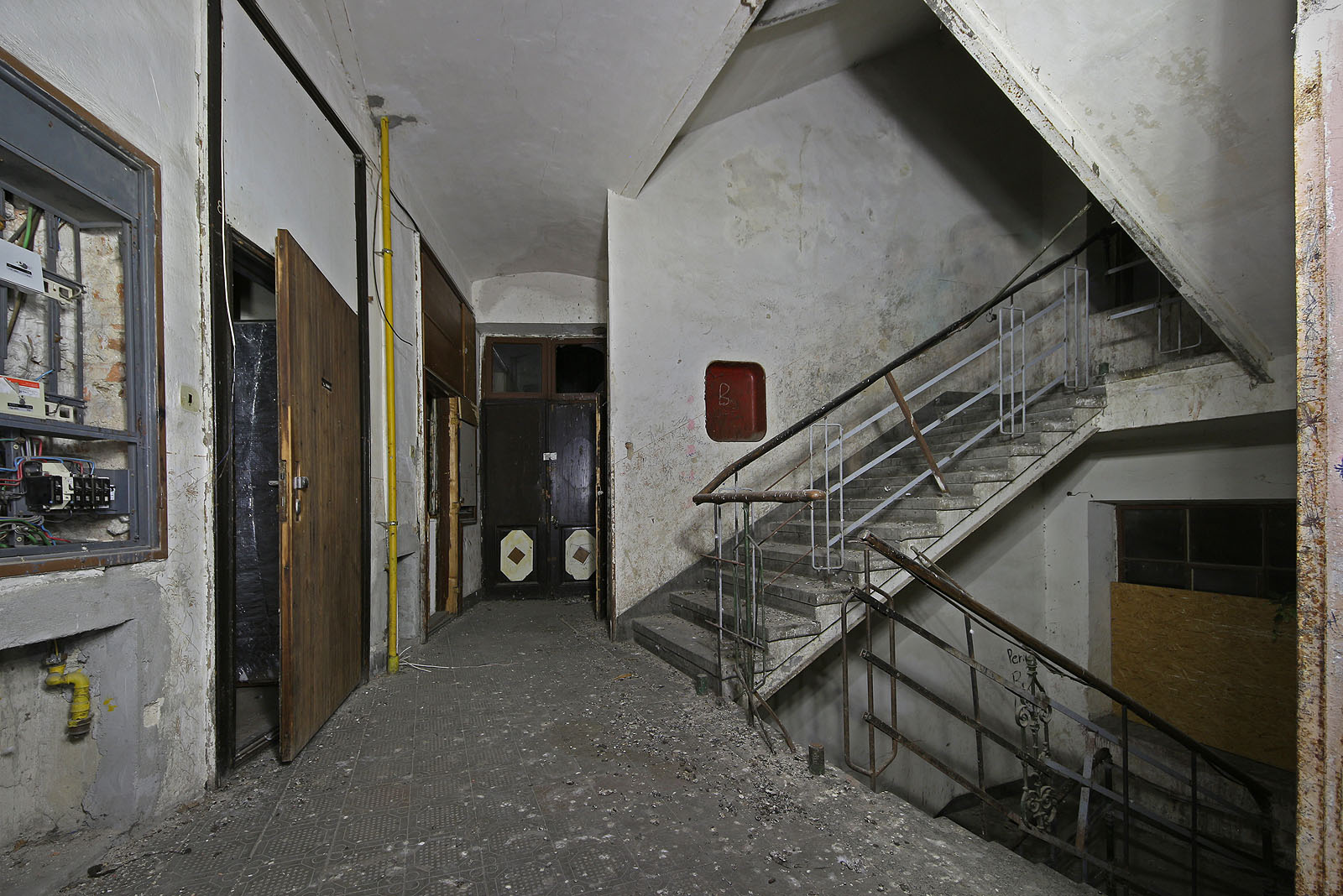 První patro a ještě nedávno provozní elektroinstalace. Ale co to tam roste, za dřevoštípkovou deskou na schodišti?