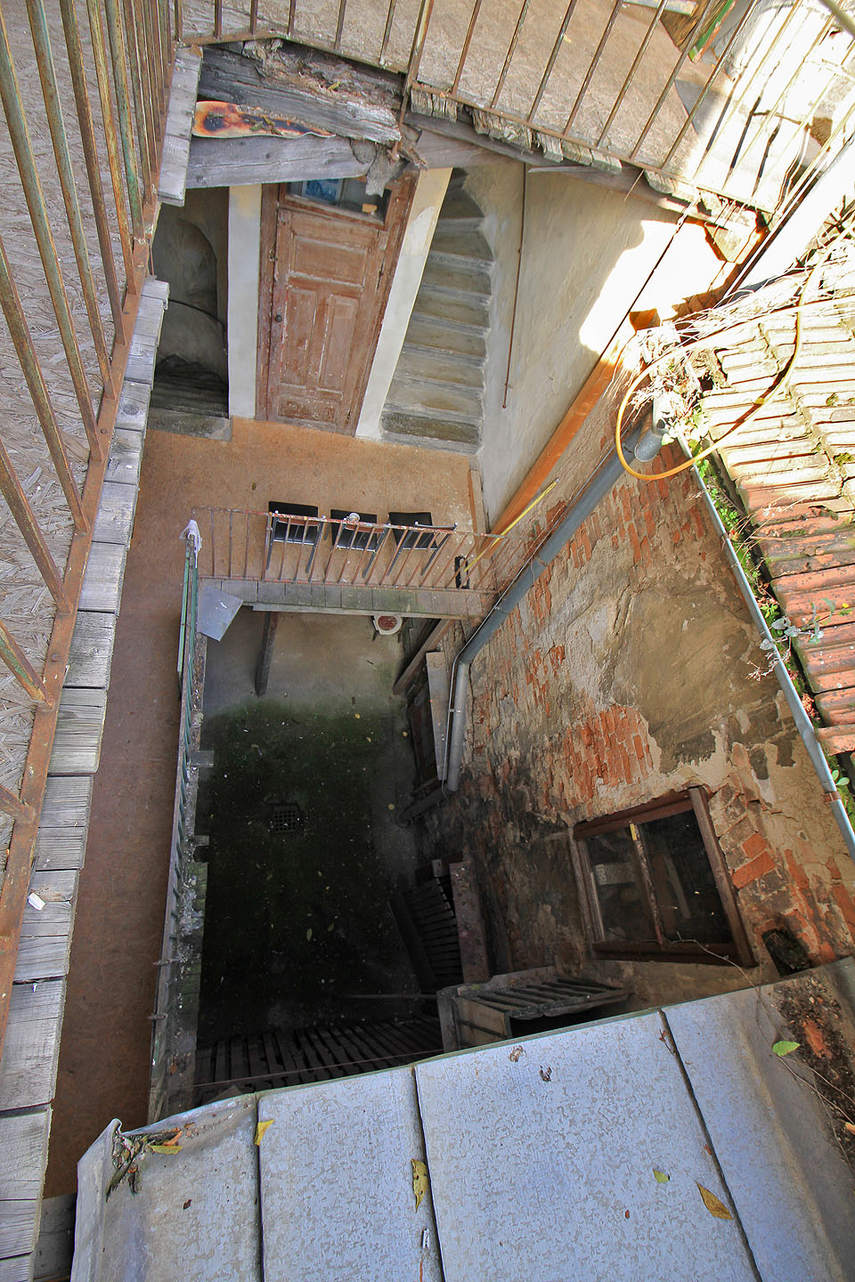 Nosná konstrukce pavlačí důvěru nevzbuzuje. Ostatně ani okapy plné hlíny ne.