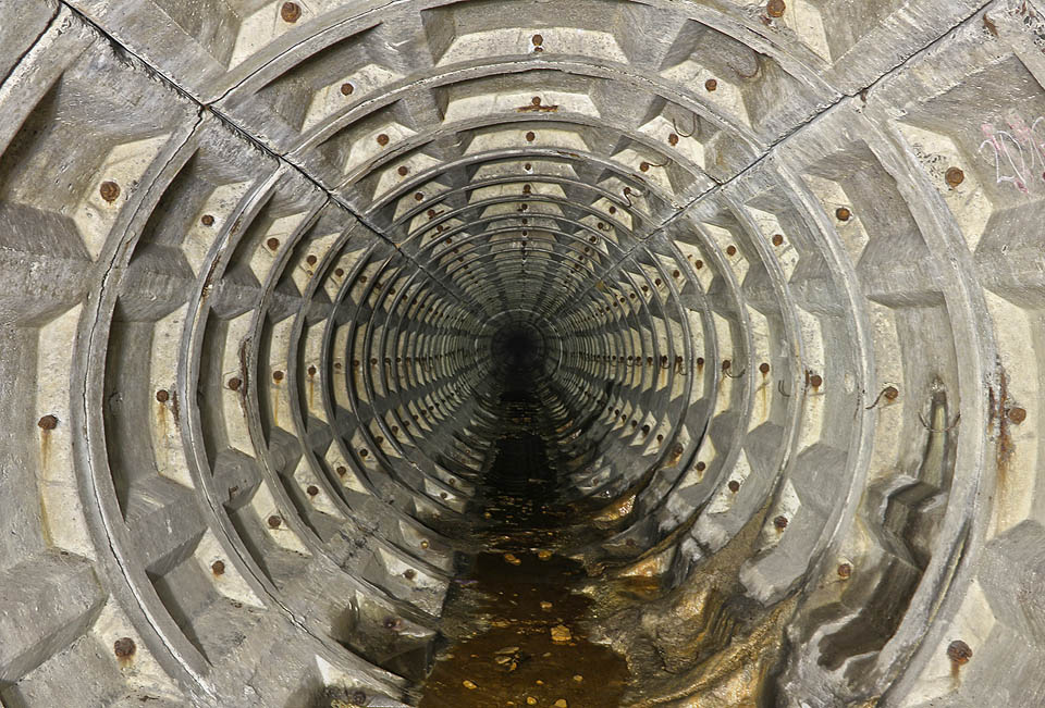 Závěrečná část štoly je přímá, prázdná a tichá. Od členitých betonových stěn se neodráží žádné zvuky.