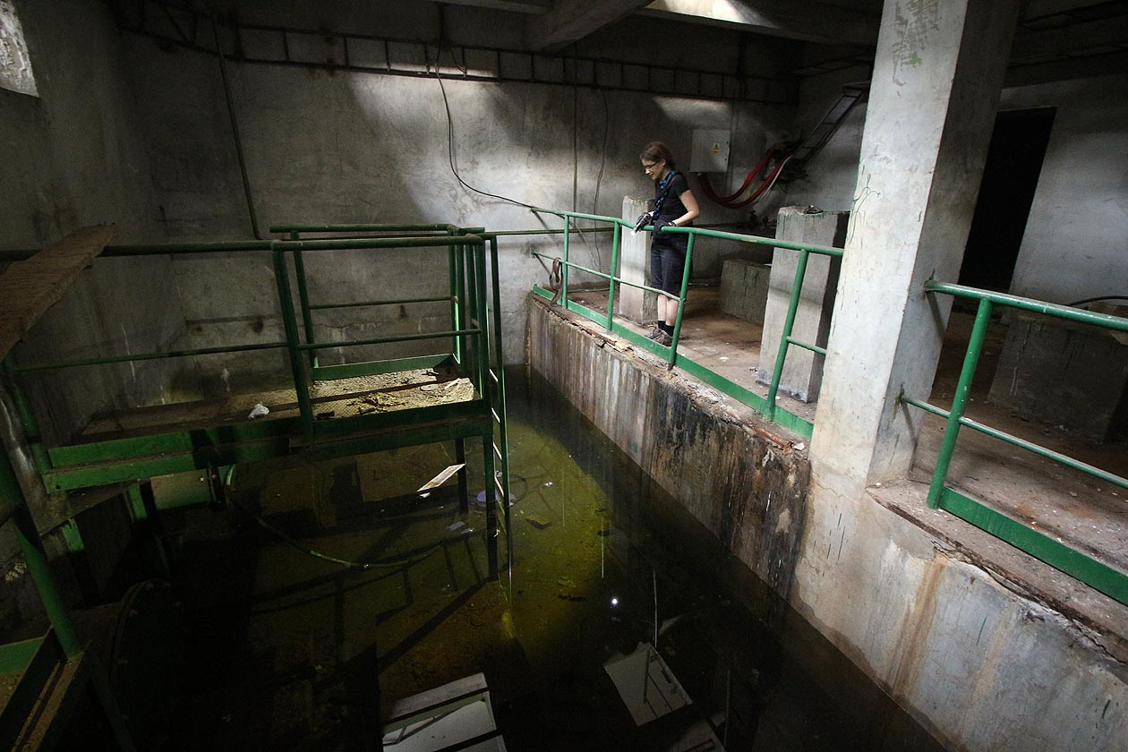 Nejnižší prostory jsou zaplněné zelenkavou vodou. Její nehybná hladina kontrastuje s tiše se valící masou vody za zdí.