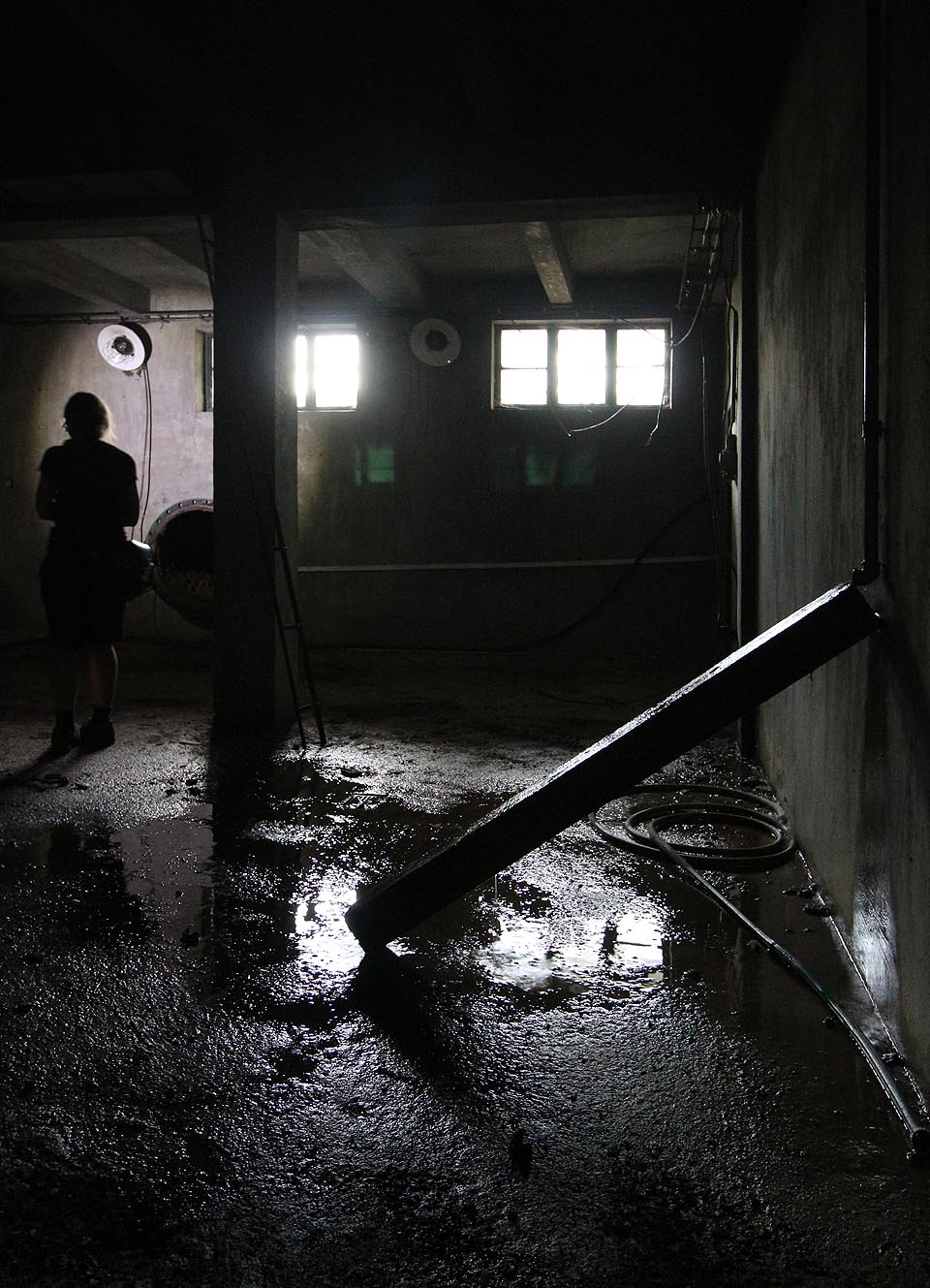 Vlevo na fotografii je vidět nevelký vstup do potrubí vedoucího k homogenizační a agregační budově, kterým lze prolézt pod zemí skrz celý areál.