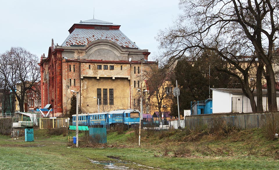 Modrý vláček se krčí pod mohutnou budovou užhorodské synagogy přestavěné po poslední světové válce na městskou filharmonii. Přejme sedmdesátileté trati samé šťastné osudy.