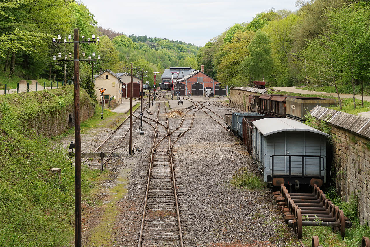 Úzkokolejka sloužila především k dovozu železné rudy do normálněrozchodné stanice Fond-de-Gras (která dnes slouží mj. jako železniční muzeum). Úzké koleje obklopují stanici z obou stran - na fotce je vidět dva výklopné vozíky vpravo na kamenné rampě, křížení s normálněrozchodnou kolejí a vjezd úzkokolejky do růžového depa menšími vraty pod komínem. Další úzká kolej se skrývá za přejezdem zcela vlevo nahoře.