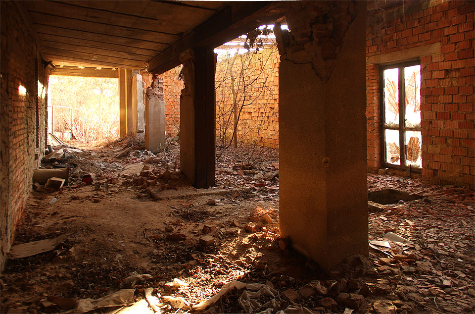 Prohlídku začínáme zezdola. Za narušeným sloupovím je vidět přístabu z 90. let 20. století. Cihly se drolí víc než ty v původních zdech.