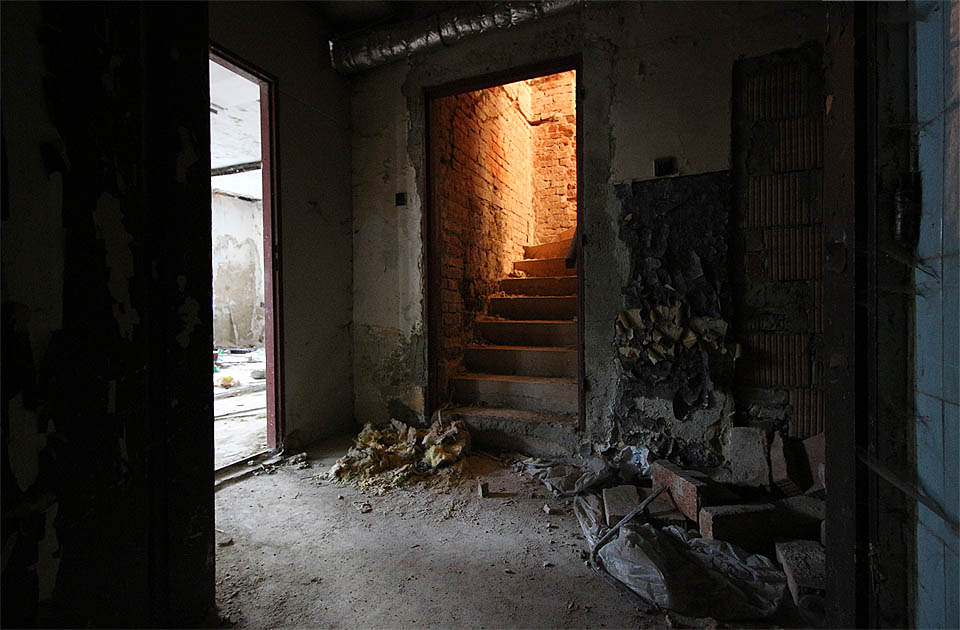 Rudá záře nad schodištěm zve rovněž k návštěvě horního patra budovy. Sklepy si necháme na později.