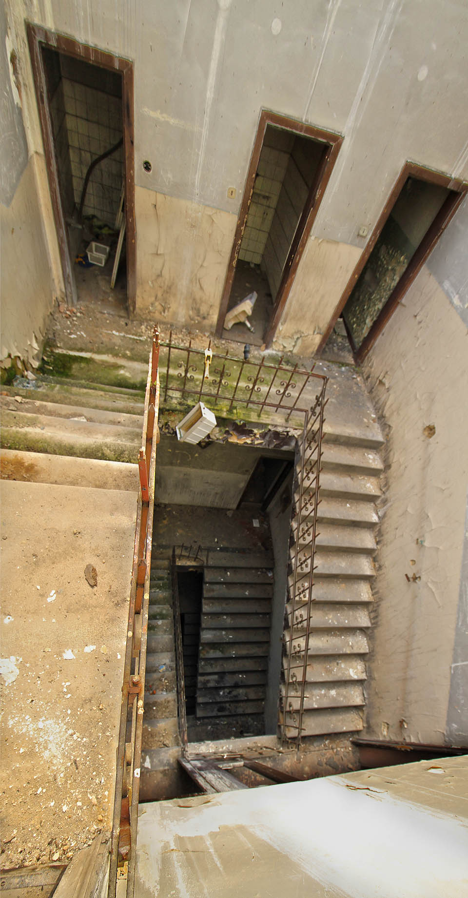 Superširokoúhlý pohled na schodiště hotelu Slezská beseda z nejvyššího patra nad zábradlím.