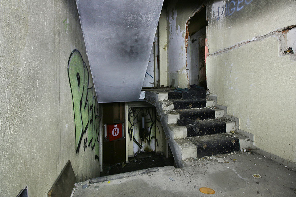 Do vyšších pater už kromě výtahu vede jen úzké lomené schodiště - směrem do svahu se nachází o metr zvýšená mezipatra. Vše zcela zničené, zakouřené, posprejované a páchnoucí.