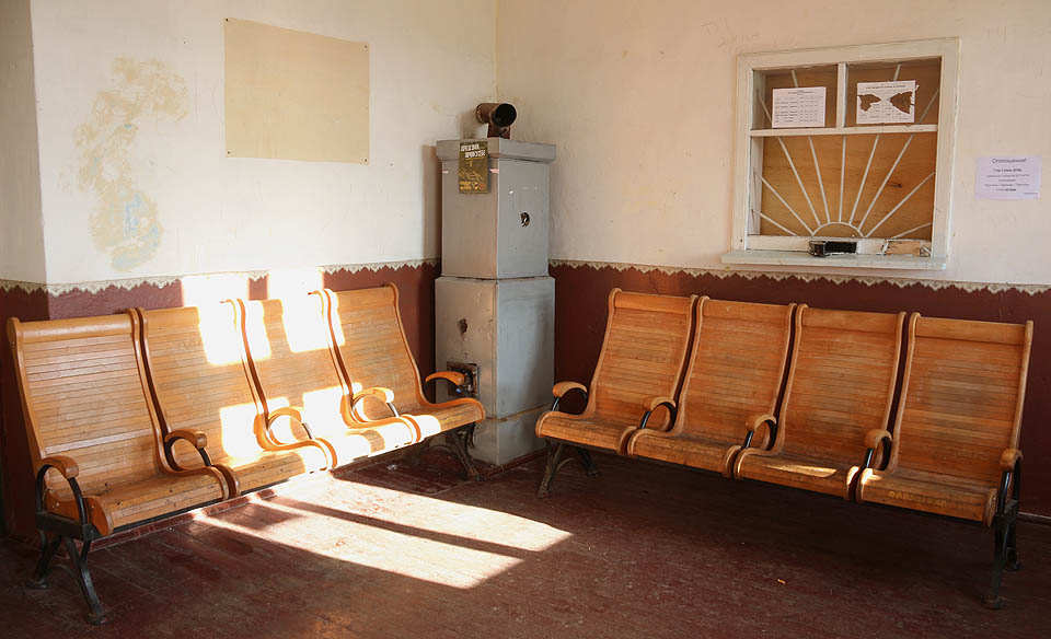 Čekárna je obrazem doby. Výdejna jízdenek zrušená, okénko zakryté překližkovou deskou. Z někdejší rakouské železniční noblesy nezbylo mnoho. Podivná, nepoužívaná kamna na uhlí pochází zřejmě z pozdější doby, moderní sedadla jsou hezká, ale stejná na všech ukrajinských nádražích.