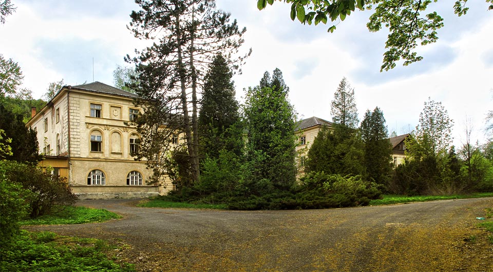 Centrální pohled na Jánské koupele a neudržovaný park, který pomalu pohlcuje hlavní lázeňskou budovu.