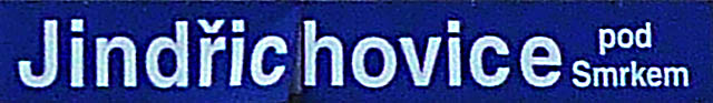 Mírně neostrá staniční cedule ve stanici Jindřichovice pod Smrkem.