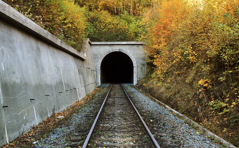 Jižní portál Jívovského tunelu navazuje na mohutný zářez opatřený zárubní zdí.