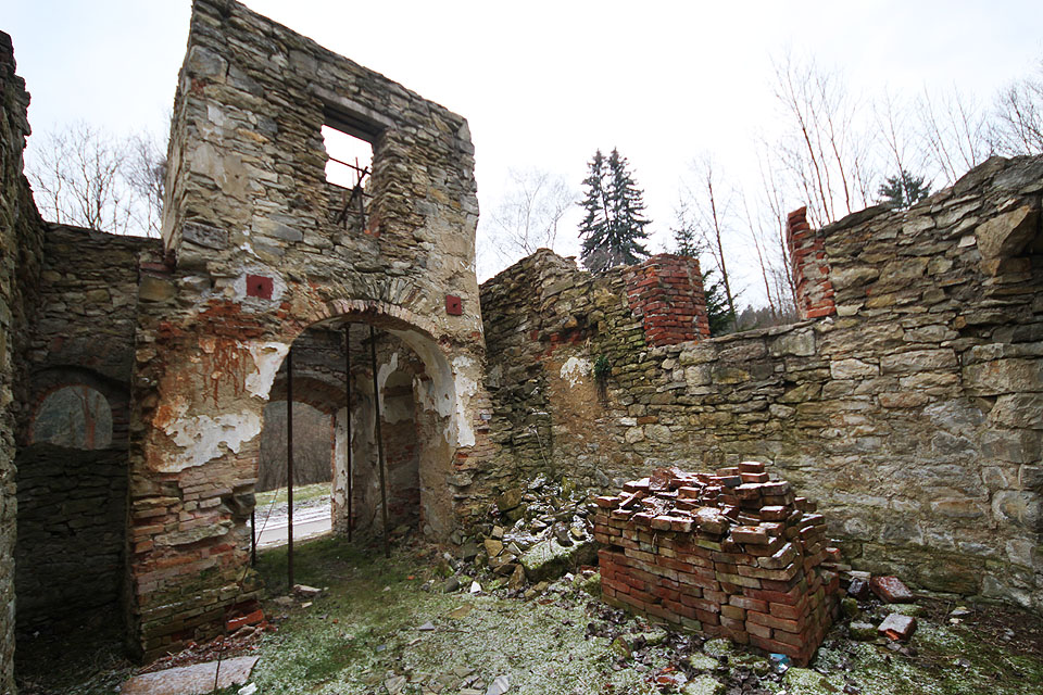 Mrazivý pohled do hlavní lodi s širým nebem nad hlavou. Podle hromady cihel je patrné, že rekonstrukce se pomalu dává do pohybu.