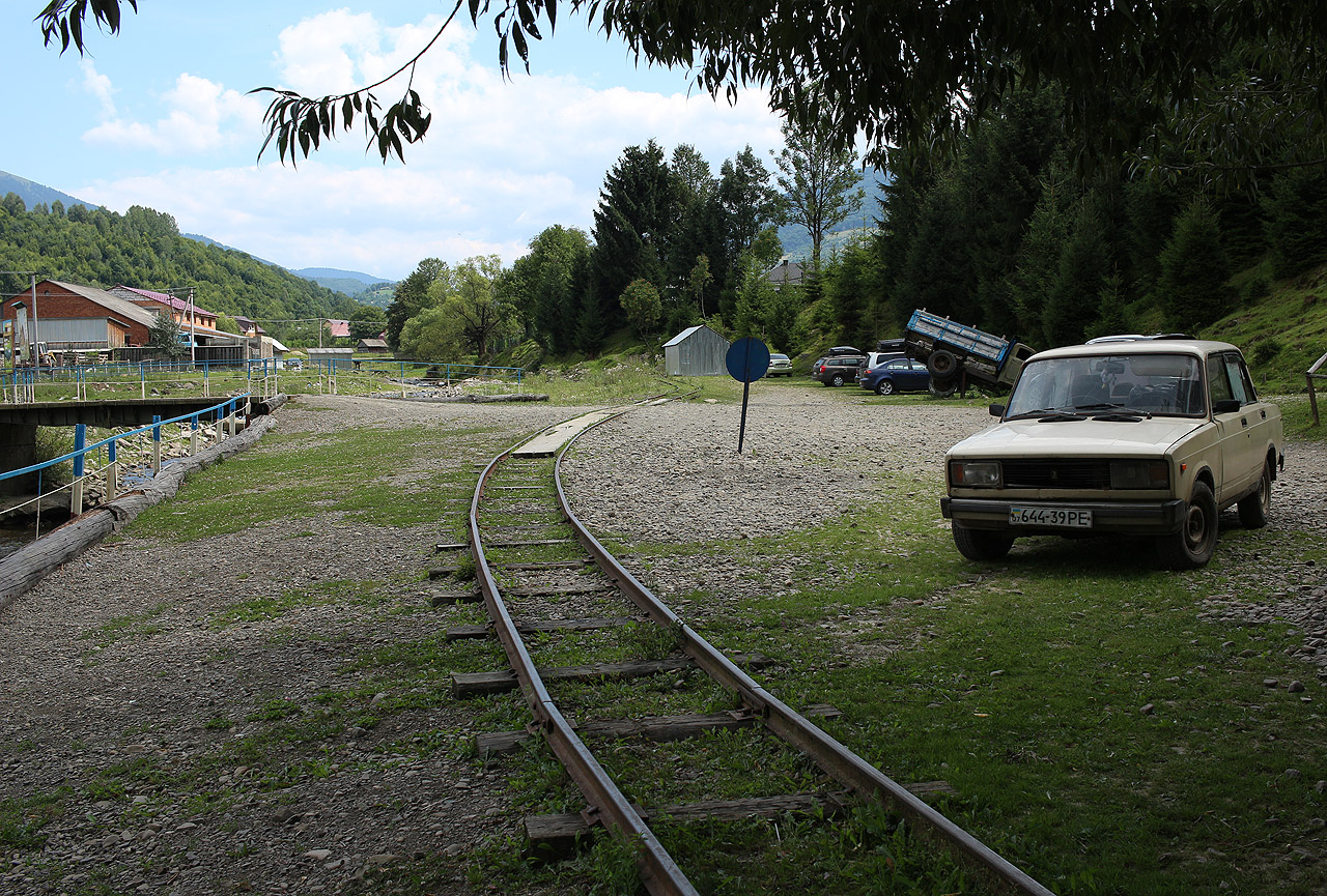 Dvojicí pozvolných oblouků elegantně prochází skrze parkoviště a vniká do oploceného areálu. Dál lze koleje sledovat až po zaplacení vstupného.