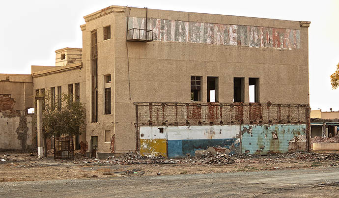 Vstup do dolního areálu bývalého závodu. Některé budovy už vzaly za své.