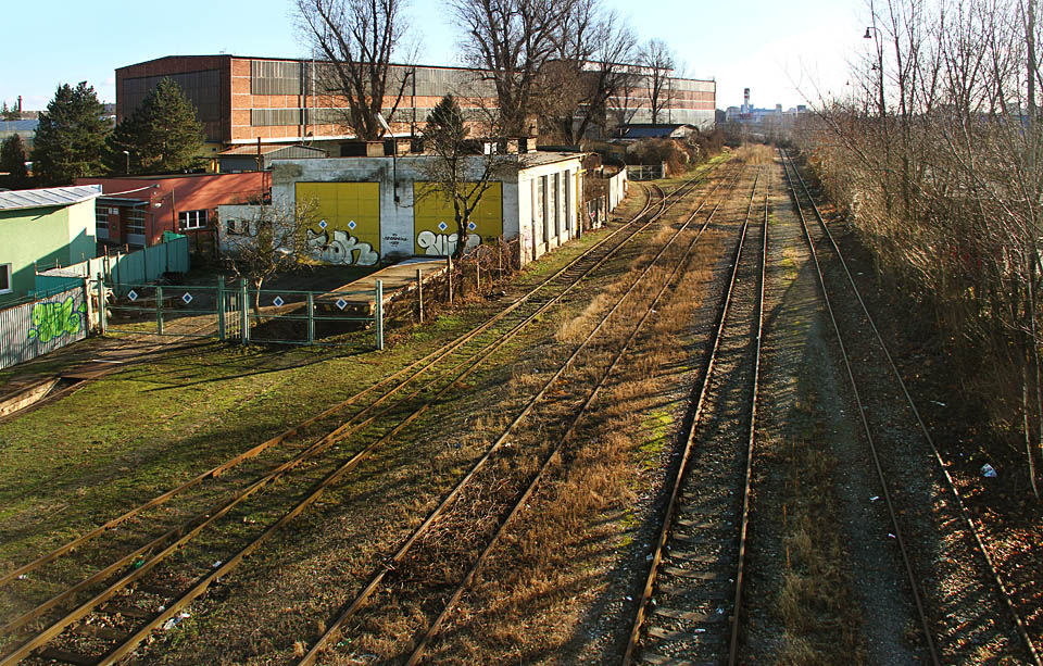 Opět pohled z lávky pro pěší, která překračuje dálnici i přilehlé kolejiště zrušené stanice. K jihojihovýchodu pokračují čtyři koleje - vlevo jedna vlečková, vpravo tři staniční.