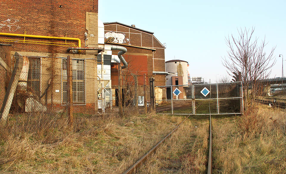 V pořadí od severu sedmá brána oddělující vlečku od stanice a za ní opět spleť kolejí, výhybek a továrních budov.