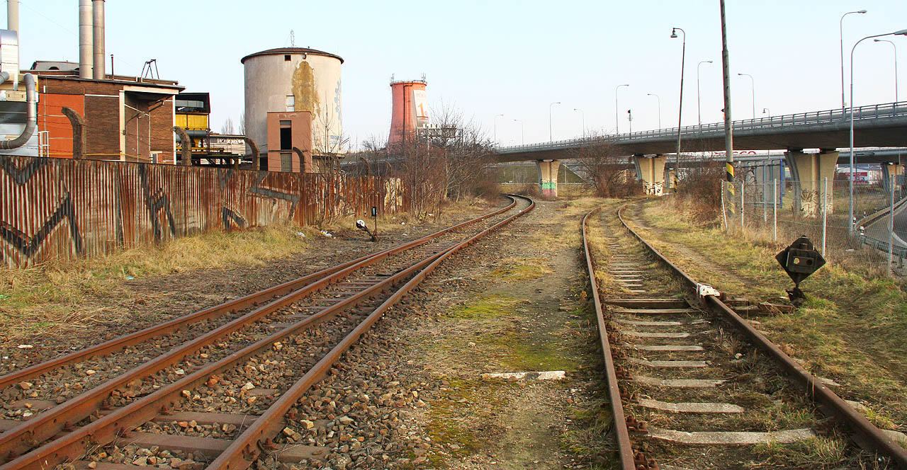 A to je definitivní konec bývalé stanice Královo Pole. Původní dráha se vlevo stává vlečkou Královopolské strojírny a míří na své kilometr dlouhé pouti k poslední, osmé, bráně do areálu, odbočující kolej vpravo tvoří začátek vlečky do teplárny Červený mlýn.