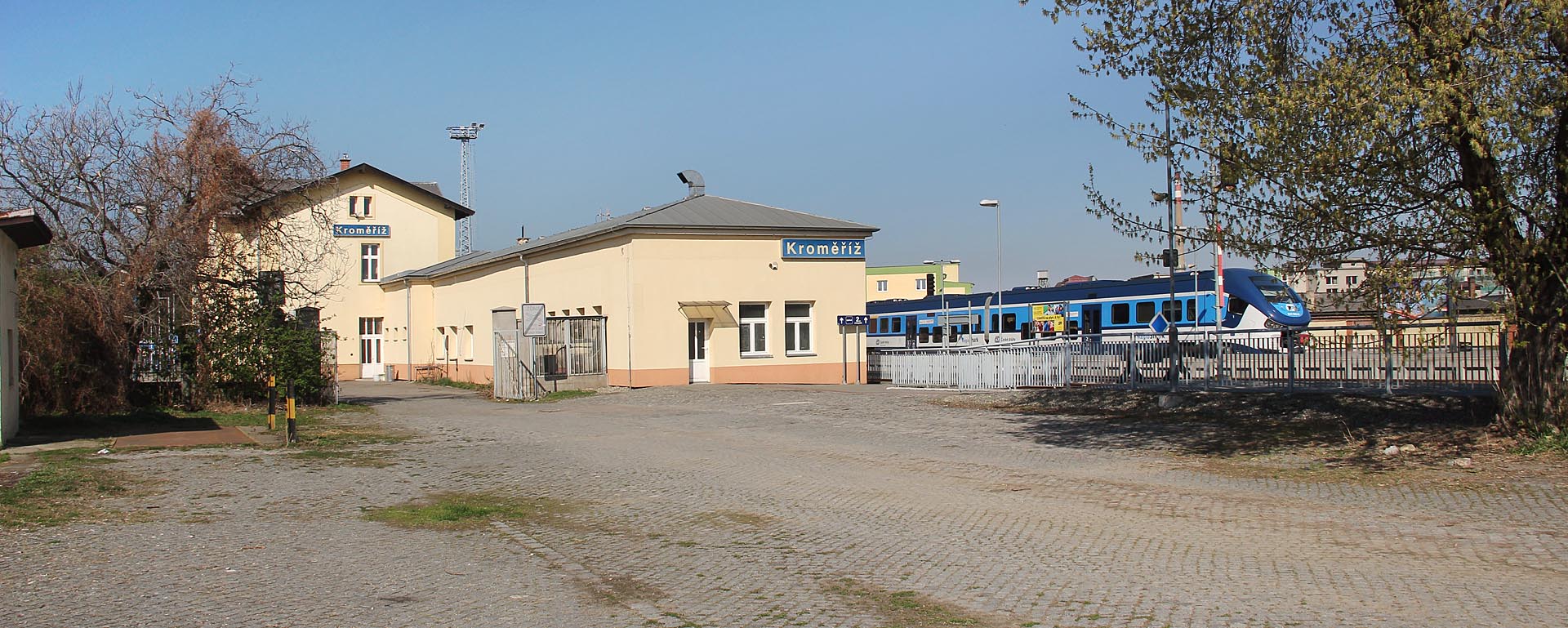 Staniční budova v Kroměříži je obklopena, jak se na Hané sluší, kamennou dlažbou a stromy poskytujícími příjemný stín v poledním horku.