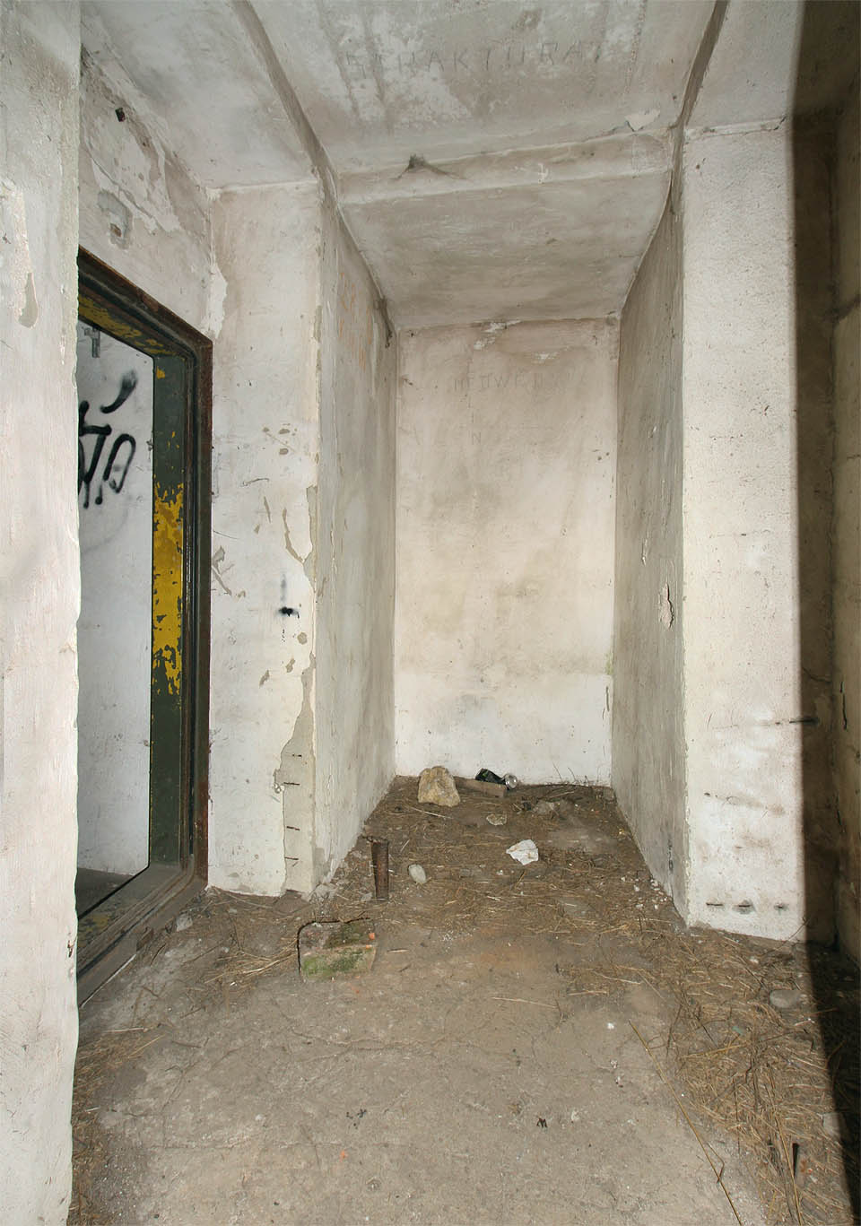 Miniaturní předsíňka umožňuje průchod jediným směrem. Přes dvojici dveří zvenčí do hlavní místnosti krytu.