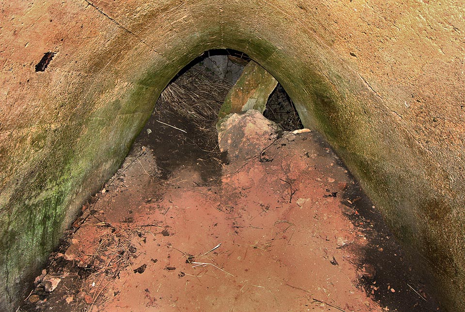 Krátká vstupní chodba je zasypána červenavou sutí a zavalena betonovým překladem. Přesto není vstup zvláště obtížný.