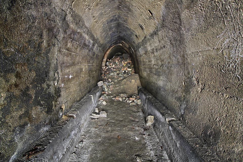 Typický profil elipsy s odseknutým dnem tvořícím podlahu a dvojicí úzkých lavic podél stěn. Původně je pravděpodobně kryla dřevěná deska.