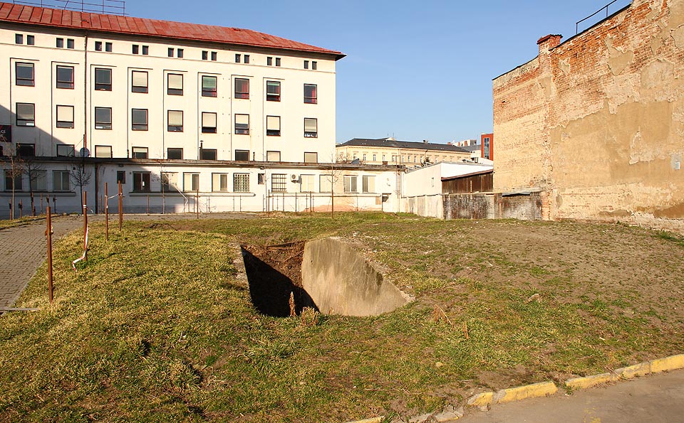 Vstup do krytu z nádvoří soukenické továrny byl bezprostřední - jámou v zemi. Dnes se na tomto místě nachází nově vybudované parkoviště pro zaměstnance a zákazníky obchodů v areálu.