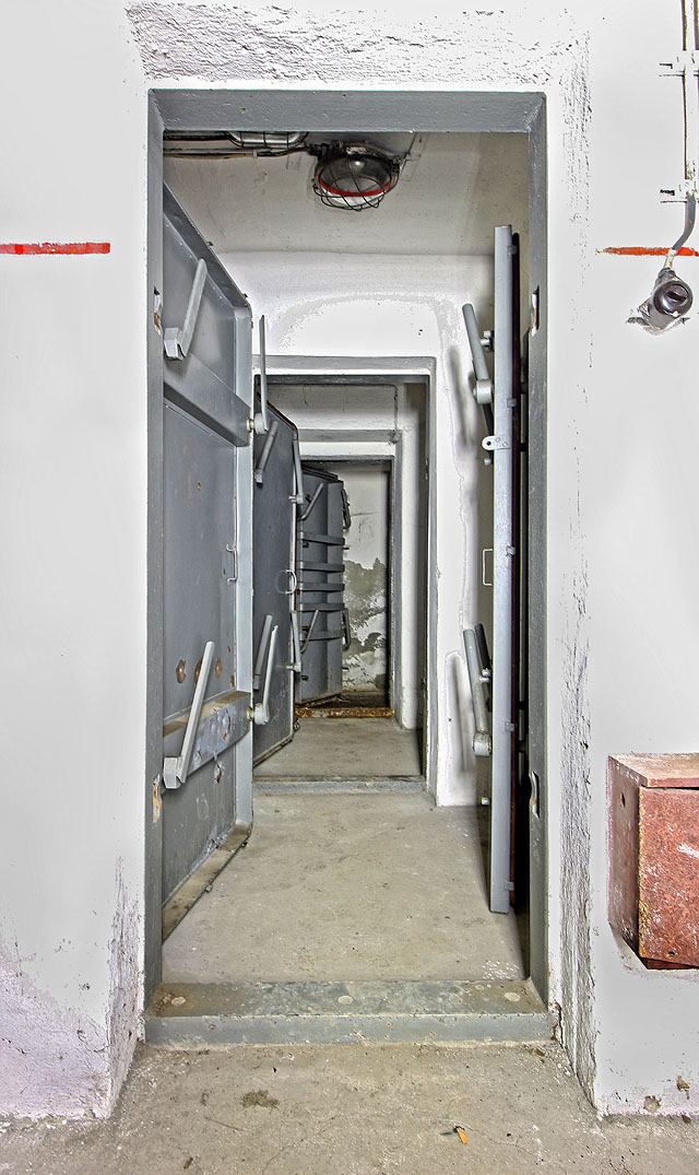 Pohled na trojici pancéřových dveří na západní straně krytu. Světlo zde stále funguje. Pohled na trojici pancéřových dveří na západní straně krytu. Světlo zde stále funguje.