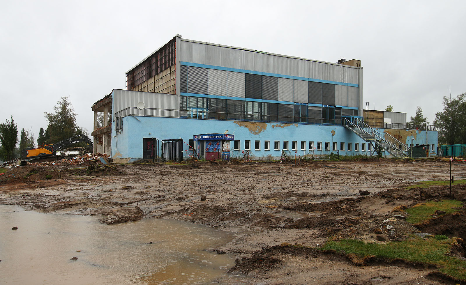 Pohled na kryté lázně v Blansku z prostoru mezi aquaparkem a zimním stadionem těsně po zahájení demolice v září 2024. 