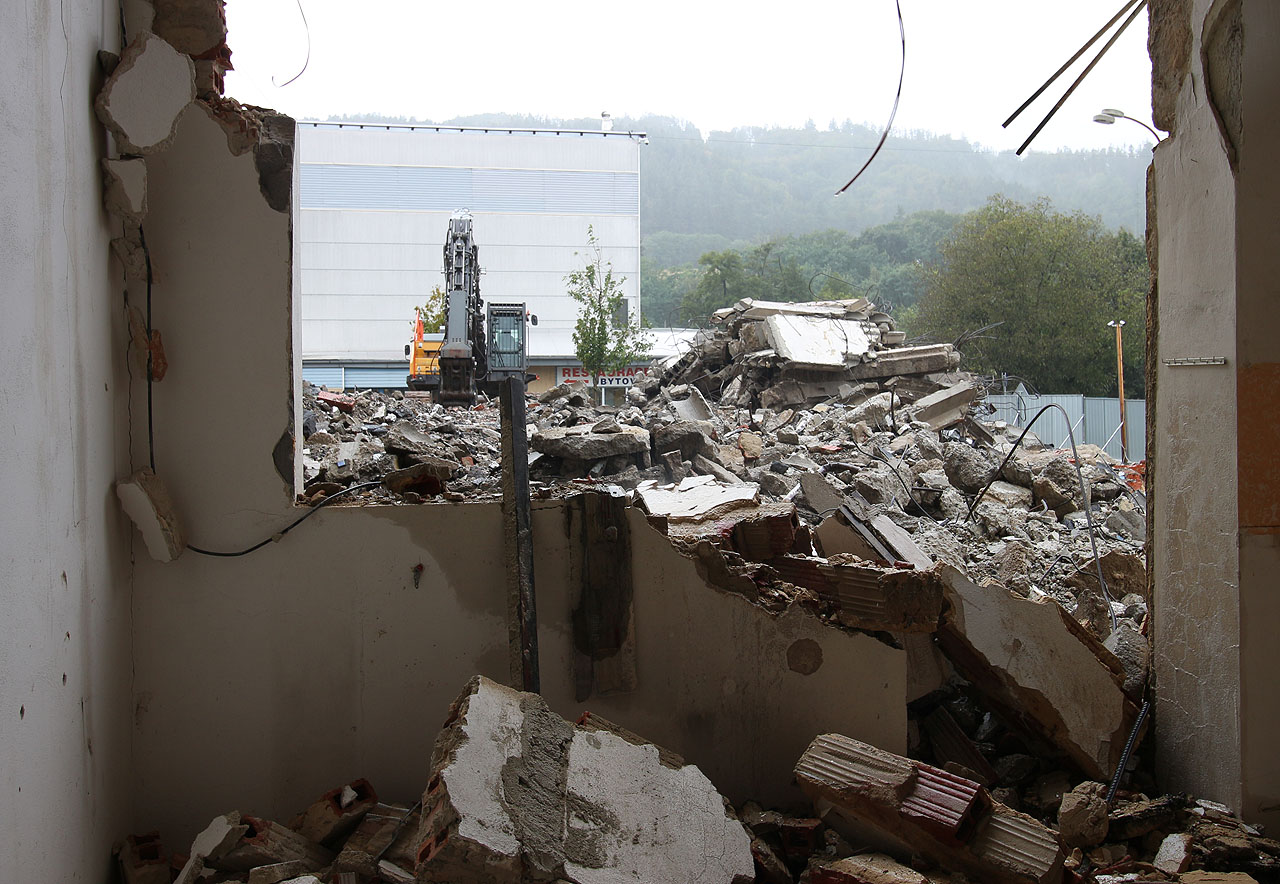 Čas oponou trhnul. Opouštíme bazén doslova na poslední chvíli, v okamžiku, kdy se do budovy zvenku již zakusují bagry.
