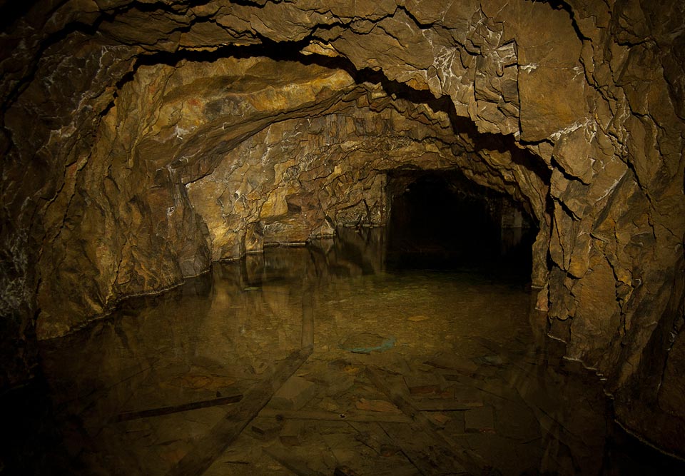 Na jižní straně hlavní chodby končí betonová vyzdívka a pokračuj už jen štola ražená přímo do kamenného podloží Hádů.