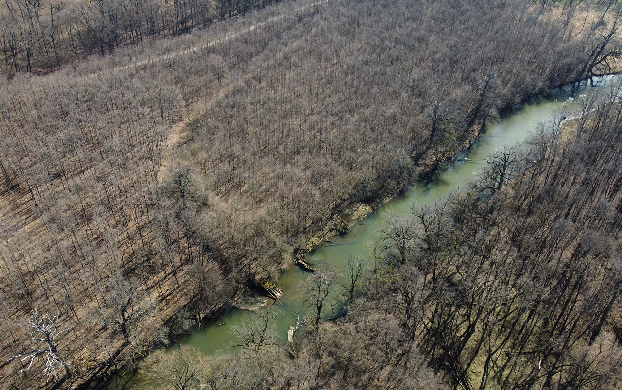 Oblouk stáčející se k jihu je za mostem i 60 let po vytrhání kolejí drážky krásně patrný.
