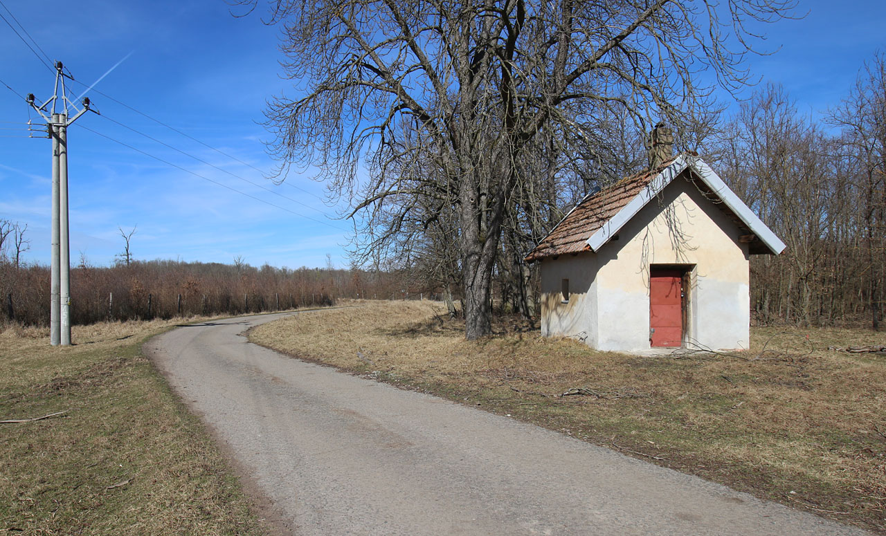 Příjezd k nákladišti Ruské domy. Těžko říct zda malá chaloupka sloužila železničnímu provozu, vlaky ale okolo ní zatáčely zcela nepochybně.