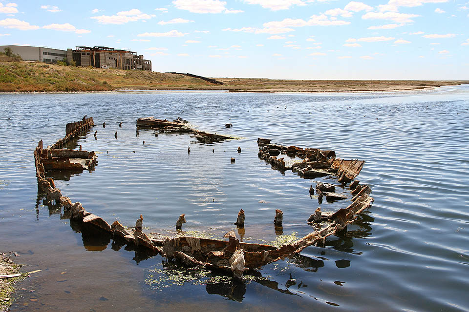 V nejhlubších vybagrovaných rýhách hluboko pod hladinou někdejšího přístavu se drží nevelká jezírka přesolené vody. Z vyschlých slanisek zatím vítr roznáší slaný prach a písek po městě. Ale voda se blíží.