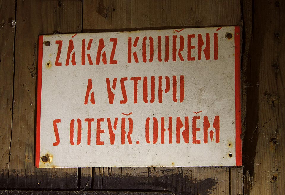 Cedule na dveřích napovídá, co bylo v krytu za strojírnou skladováno. Především šlo o chemikálie a hořlaviny.