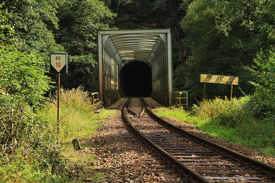 Od malebného vyvýšeného strážního domku je vidět přes řeku severní portál Malého Plasského tunelu a upozornění na blížící se zastávku Horní Hradiště.