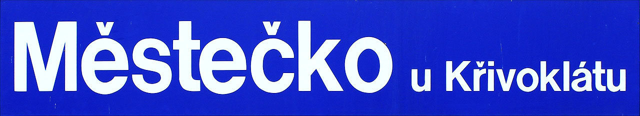 Moderní cedule na staniční budově v zastávce Městečko u Křivoklátu.