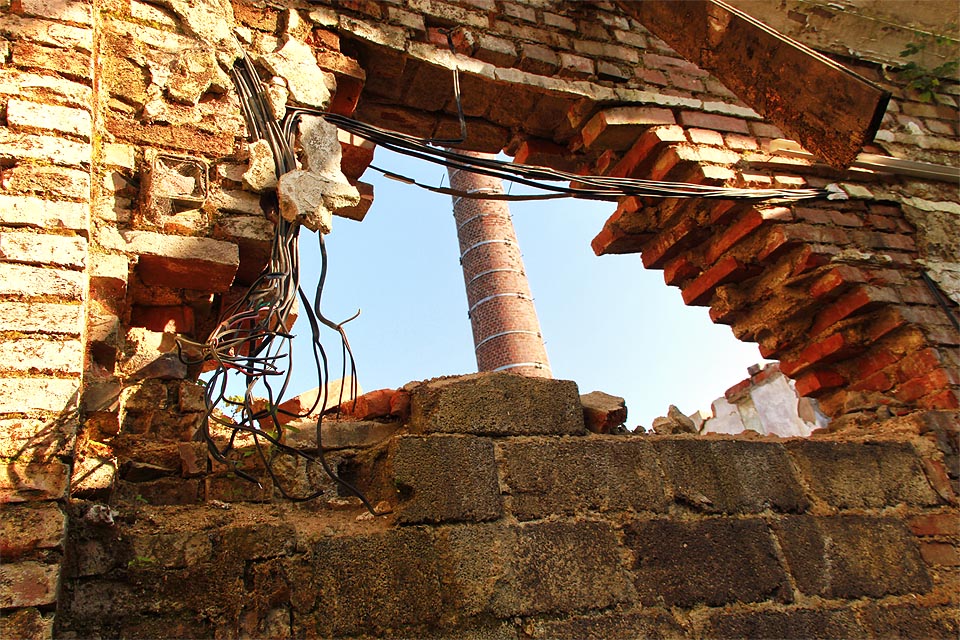 Komín nyní soupeří se zdmi zpuchřelé haly o to, kdo se zhroutí dřív. Hala mírně vede…