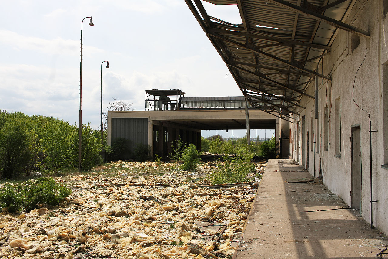 Pod vrstvou rozcupované tepelné izolace z fasády mlýna nejsou koleje vlečky téměř vůbec vidět.