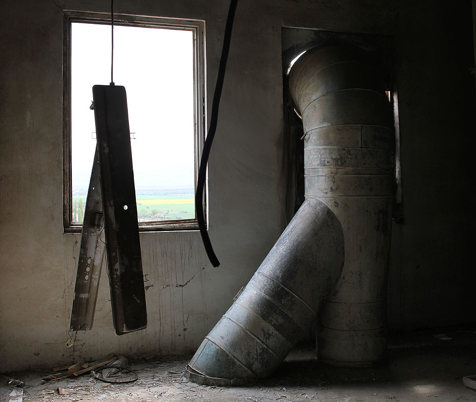 Pohled z okna skýtá výhled na široširé pláně a hory v dálce.