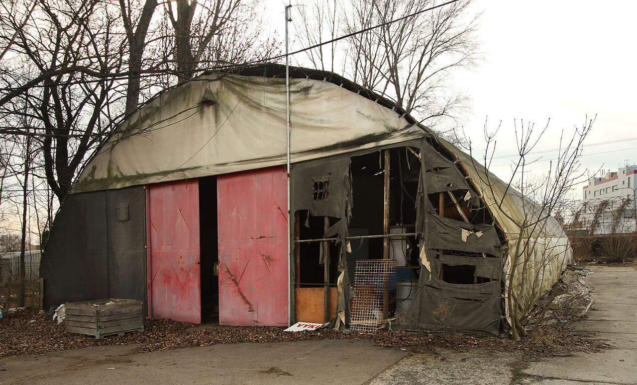 Zaplachtovaná hala obrůstající křovím je zdevastovaná tak akorát, aby ještě byla zajímavá, ale už do ní bylo možné nakouknout.