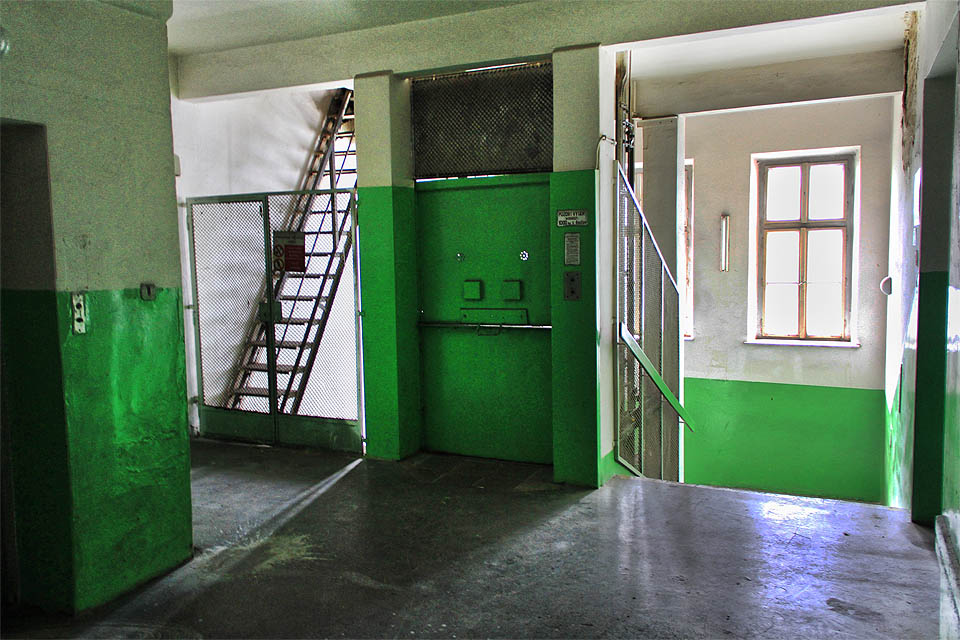 Pětipodlažní budova zadního traktu je natřena zářivě zelenou olejovou barvou. Inu, v továrnách se na krásu nikdy moc nehledělo.